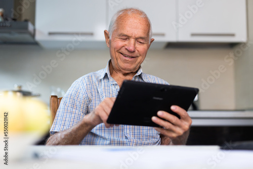 Grandfather man doing online payment from digital tablet. Elderly senior caucasian grandpa paying bills online
