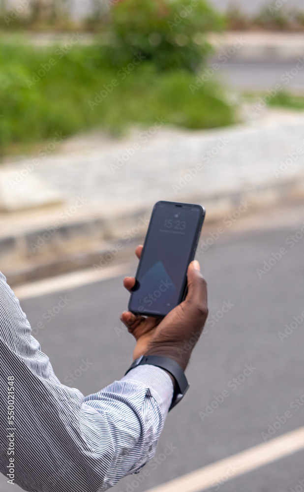 Jeune homme africain montre l'écran de son smartphone Photos | Adobe Stock