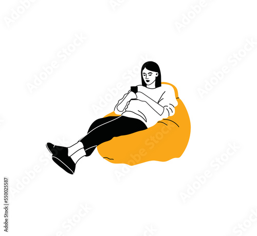 Woman sitting on sofa pouf holds smartphone in her hand. Casual lady and browsing social media on mobile device. Girl on couch uses phone for chatting and surfing internet