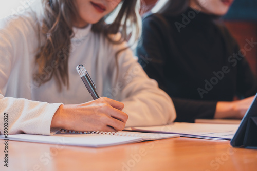 Photography Teenage Asian girl student studying online write on a notebook with a laptop on
