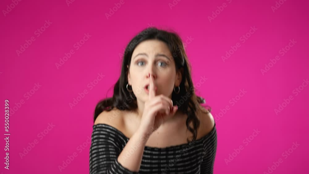 Portrait of hipster woman 20s looks around put finger to lips shh quiet isolated on pink background studio portrait Portrait of hipster woman 20s looks around put finger to lips shh quiet isolated on pink background studio portrait