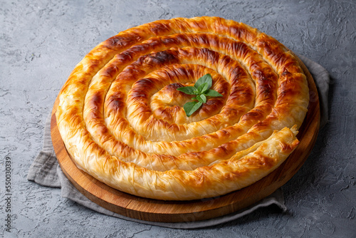 Traditional Turkish pastry with spinach. (Turkish Name: Ispanakli Kol Boregi, Bosnak boregi). Handmade pastry with spinach filling. photo