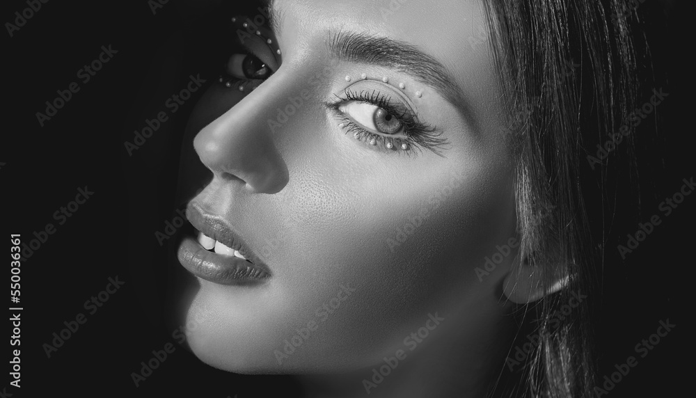 Fototapeta premium Young woman with decorative beaded eye makeup. Eyelashes. Cosmetic Eyeshadow. Make-up detail. Monochrome