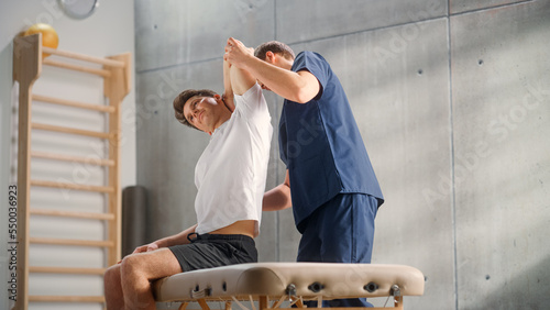 Professional Sport Physiotherapist Working on Specific Muscle Groups and Neck Pain with Young Male Athlete. Sportsman Recovering from Mild Injury. Trauma Prevention Therapy or Rehabilitation at Clinic photo