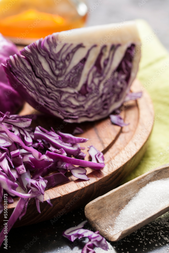 Rotkohlstück mit geraspeltem Kohl auf einem Schneidebrett mit Salz und Apfelessig Rotkohlstück mit geraspeltem Kohl auf einem Schneidebrett mit Salz und Apfelessig