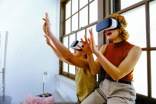 Female couple wearing VR headsets