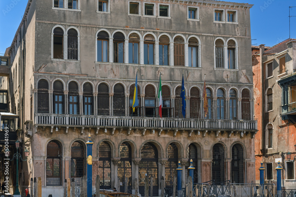 Flag of Ukraine, the European Union, the flag of Italy and Venice on the vintage wall of an administrative building in the street of the city of Venice. European solidarity with the struggle Ukraine