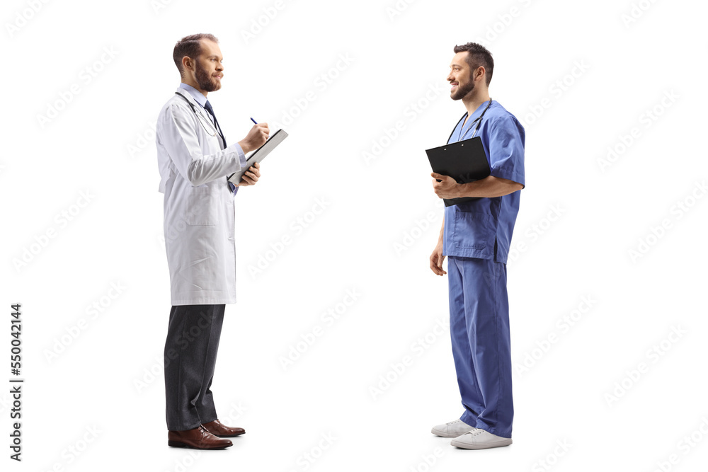 Full length profile shot of a male doctor standing and talking to a healthcare worker Full length profile shot of a male doctor standing and talking to a healthcare worker