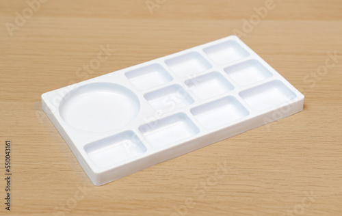 White watercolor palette. Empty watercolor tray isolated on wood background. White palette.