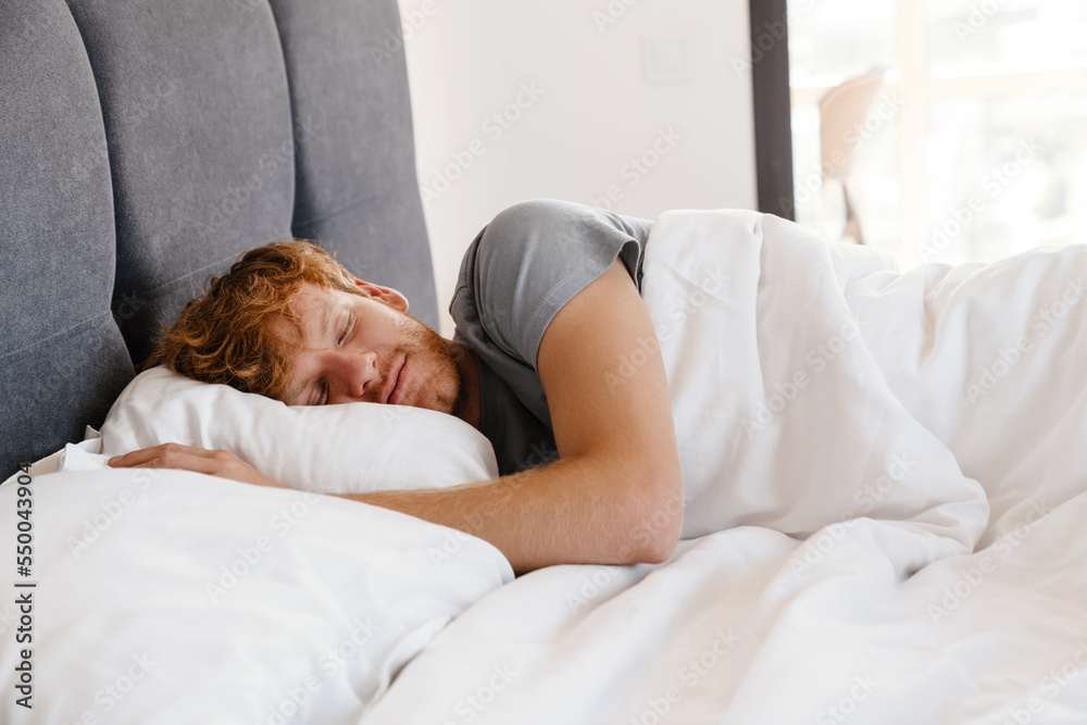 Portrait of young handsome sleeping redhead man in gray t-shirt Portrait of young handsome sleeping redhead man in gray t-shirt