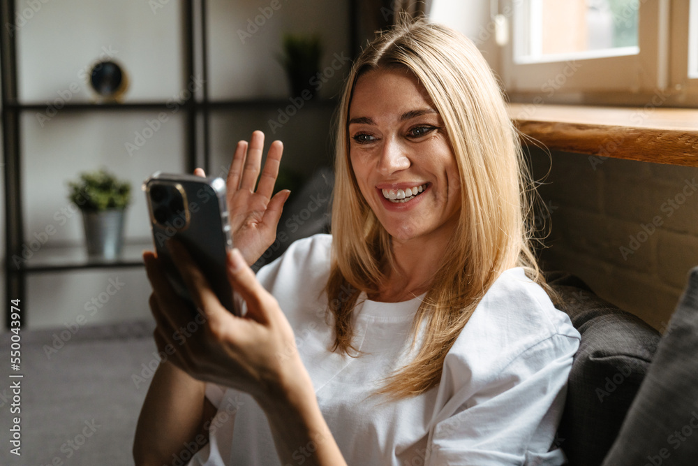 Blonde white woman taking selfie on cellphone while resting on couch Blonde white woman taking selfie on cellphone while resting on couch