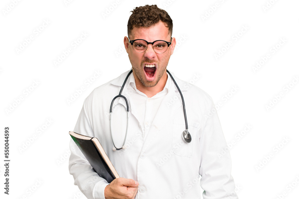 Young doctor caucasian man holding a book isolated screaming very angry and aggressive. Young doctor caucasian man holding a book isolated screaming very angry and aggressive.
