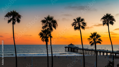 Sunset beach with palm trees in Manhattan Beach, California. Fashion travel and tropical beach concept.