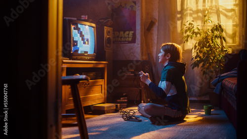 Young Boy Playing Eighties Eight Bit Arcade Video Game on a Gaming Console at Home in His Room with Old-School Interior. Child Successfully Wins the Level. Nostalgic Childhood Concept.