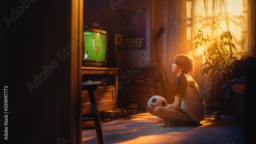 Young Sports Fan Watches a Soccer Match on TV at Home. Curious Boy Supporting His Favorite Football Team  Feeling Proud When Players Score a Goal. Nostalgic Retro Childhood Concept.
