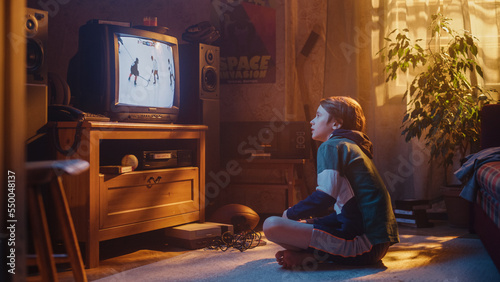Nostalgic Retro Childhood Concept. Young Boy Watches Hockey Match on TV in His Room with Dated Interior. Supporting His Favorite Team, Being Focused on His Favourite Player in Action.