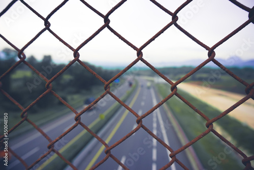 the bridge wire fence with blurred background over the toll road used to protect road users from falling when crossing the road during the day or at night
