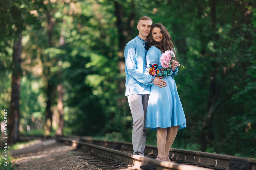 a happy couple in blue embroidered clothes is walking along the