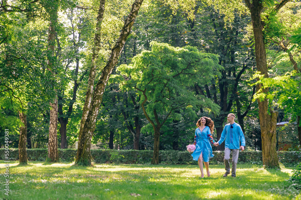 the bride and groom are having fun, running on the green grass holding hands. the bride and groom are having fun, running on the green grass holding hands.