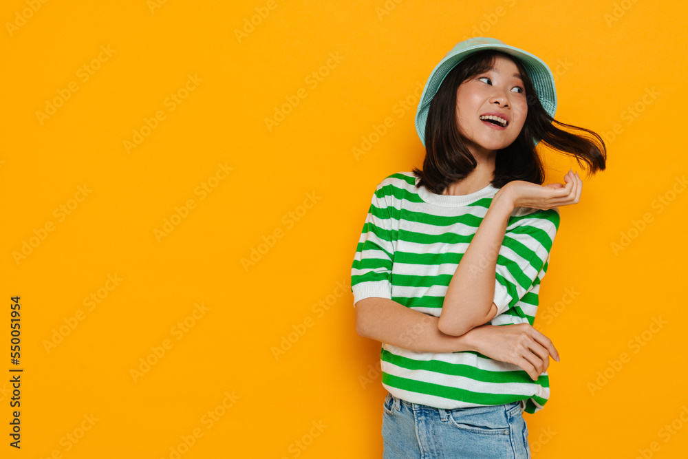 Asian young woman wearing panama smiling and looking aside Asian young woman wearing panama smiling and looking aside