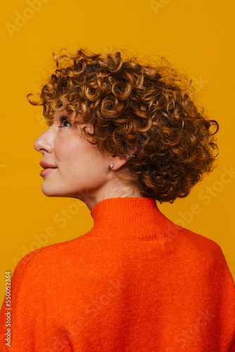Profile of mature woman looking up isolated over yellow background