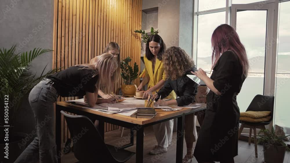 Group of office workers in a meeting around a table with lots of papers. Group of office workers in a meeting around a table with lots of papers.