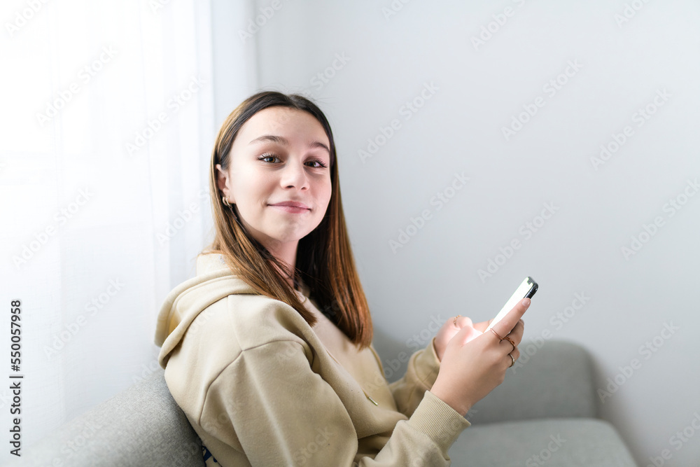 teen girl checking social media holding smartphone at home teen girl checking social media holding smartphone at home