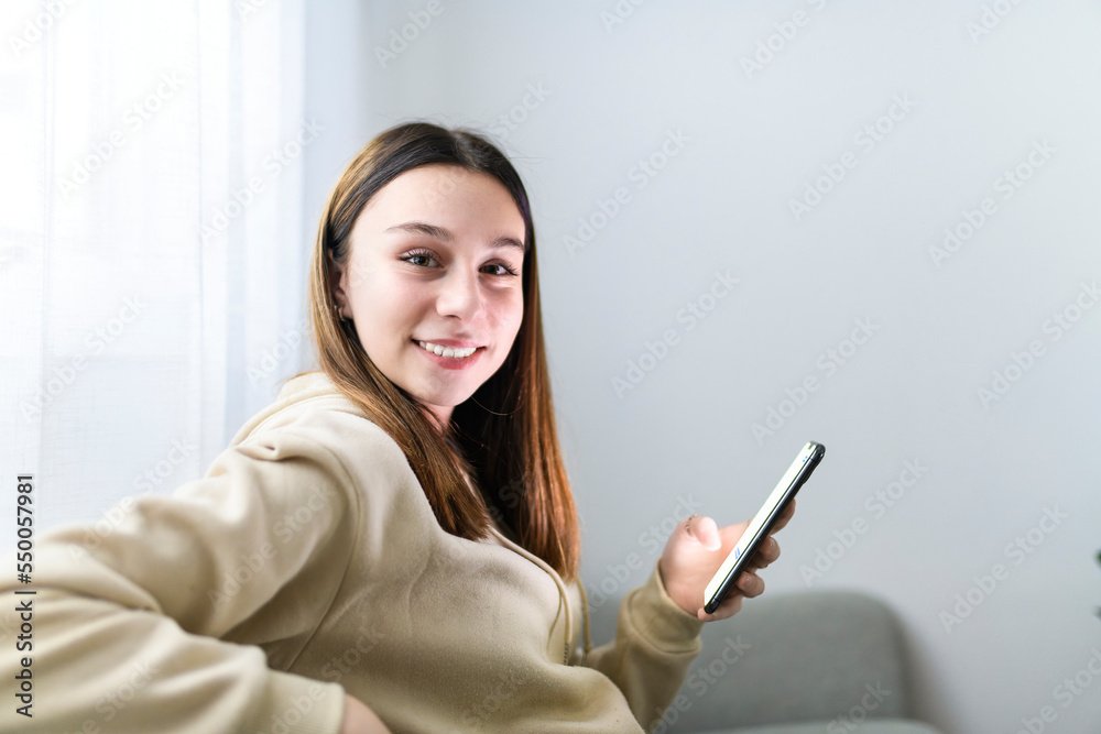 teen girl checking social media holding smartphone at home teen girl checking social media holding smartphone at home