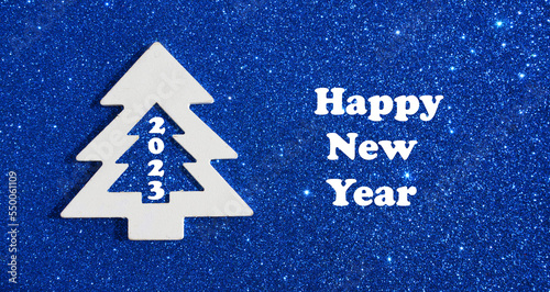 White christmas tree with 2023 number on gllitter blue background.Happy new year 2023 concept.Winter holidays.