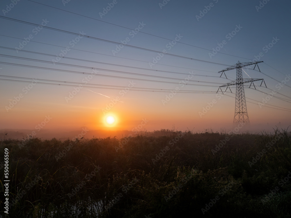 Three-phase electric power Transmission Lines at sunrise near Amsterdam Three-phase electric power Transmission Lines at sunrise near Amsterdam