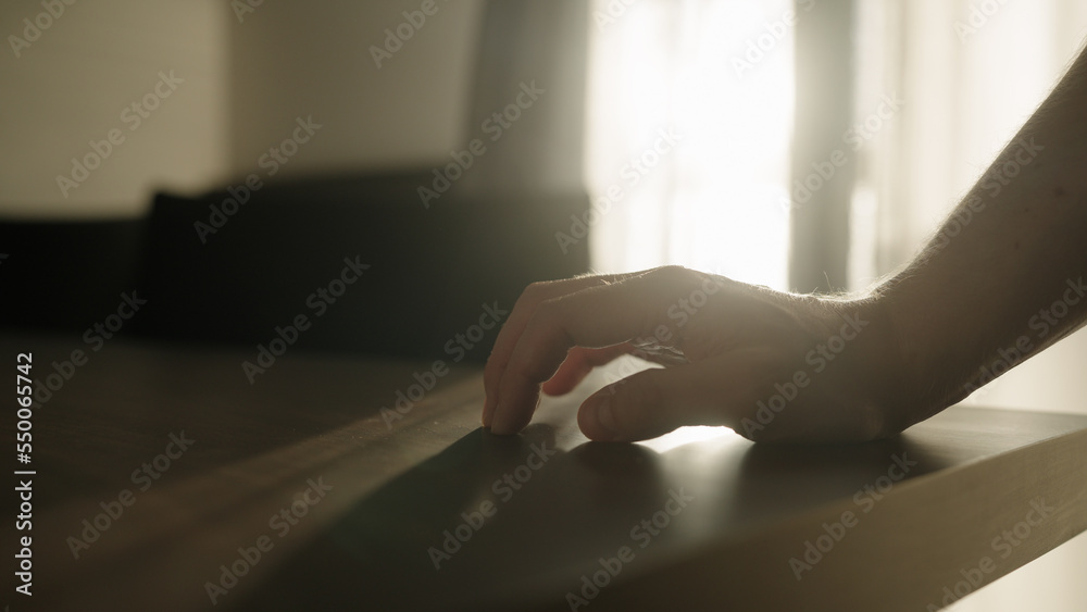 Man finger tap on walnut wood table indoor Man finger tap on walnut wood table indoor