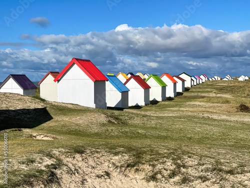 Φωτογραφία Beautiful shot of cabins with colorful roofs on the beach at Gouville-sur-Mer, N