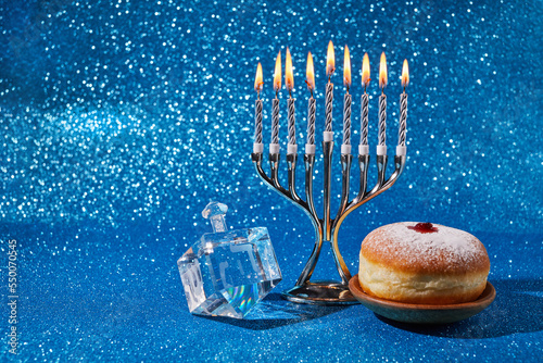 Jewish holiday Hanukkah background with menorah and dreidel with letters Gimel and Nun.
