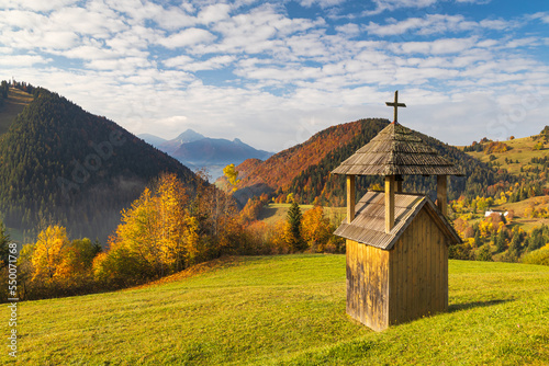 A small wooden bell tower in the foreground of a mountain landscape. Mala Fatra National Park, near the village of Zazriva in Slovakia, Europe photo