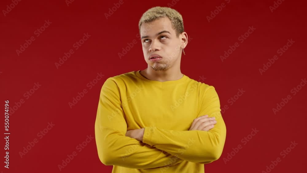 Bored upset man sighs on red background. Guy rolling eyes in displeasure, he is tired of situation, empty promises, talks Bored upset man sighs on red background. Guy rolling eyes in displeasure, he is tired of situation, empty promises, talks