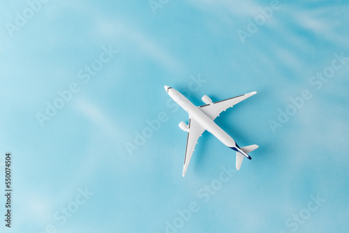 White model airplane on blue background. Travel concept.
