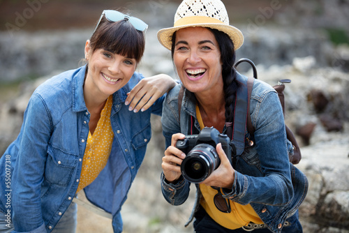 two women taking photos outdoors © auremar