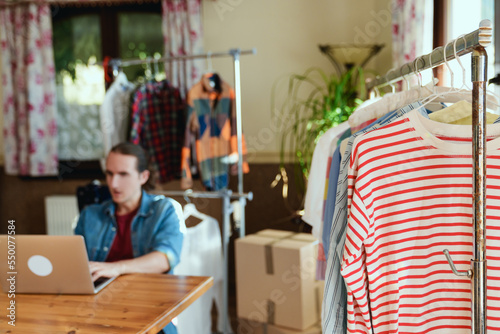 Clothes hanging on rail, concept of pre owned clothes resale or donation.