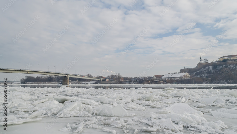 The bank of the Danube river covered with snow. Danube River covered with snow and ice. Frozen and snow-covered waterway of Danube river below Petrovaradin fortress, Vojvodina, Novi Sad, Petrovaradin,