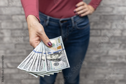 woman holding one hundred dollars in her hand.
