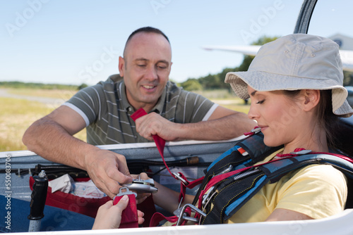 adventurous woman being strapped into sailplane