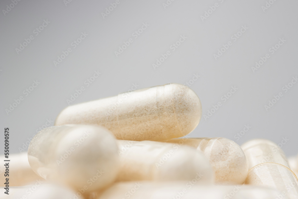 White medicine capsules, vitamin pills or drugs, medication treatment, health care concept White medicine capsules, vitamin pills or drugs, medication treatment, health care concept
