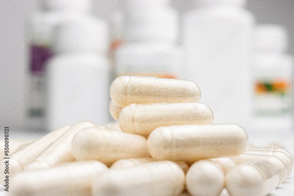 White medicine capsules, vitamin pills or drugs, medication treatment, health care concept White medicine capsules, vitamin pills or drugs, medication treatment, health care concept