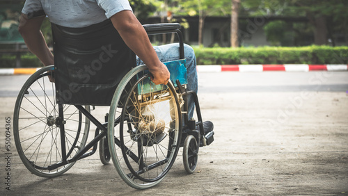 Behind an Asian elderly man traveling in a wheelchair by himself, to people and health care concept.