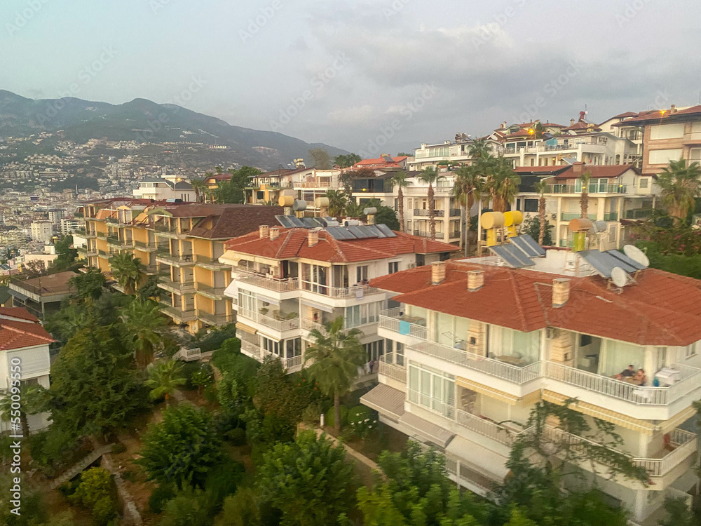 A beautiful tourist city with modern buildings on a mountain with trees, a view from the top of the rooftops on vacation in a warm tropical eastern paradise country southern resort