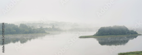 Serene landscape with a lake in the fog © v_blinov