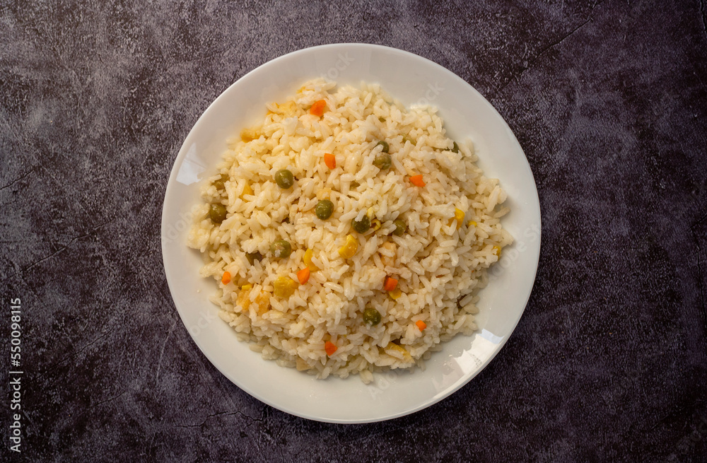 Vegan rice with vegetables, shot from above on a black background Vegan rice with vegetables, shot from above on a black background
