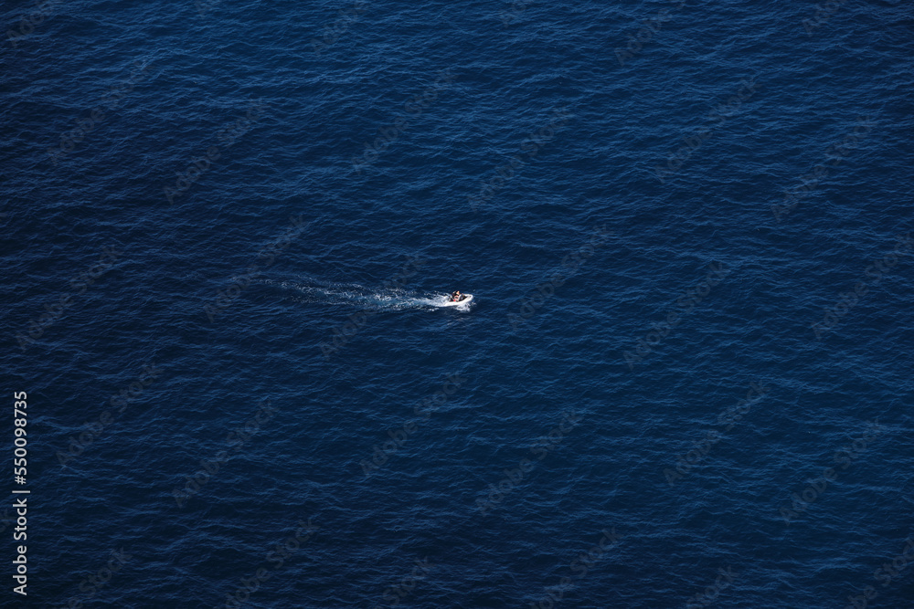 Small boat in the middle of the blue ocean. Small boat in the middle of the blue ocean.