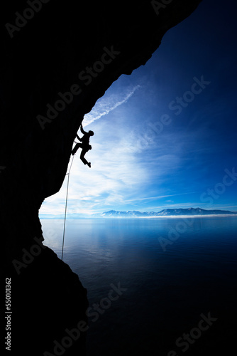 Man climbing against blue sky.