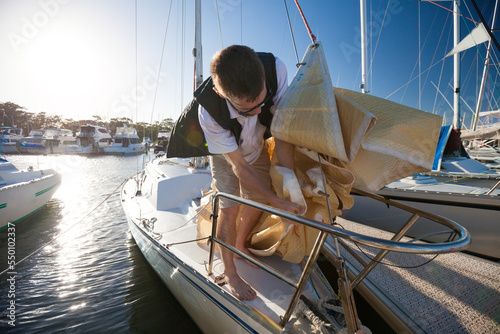 Sailor attaching jib on foredeck, Perth, Western Australia, Australia photo